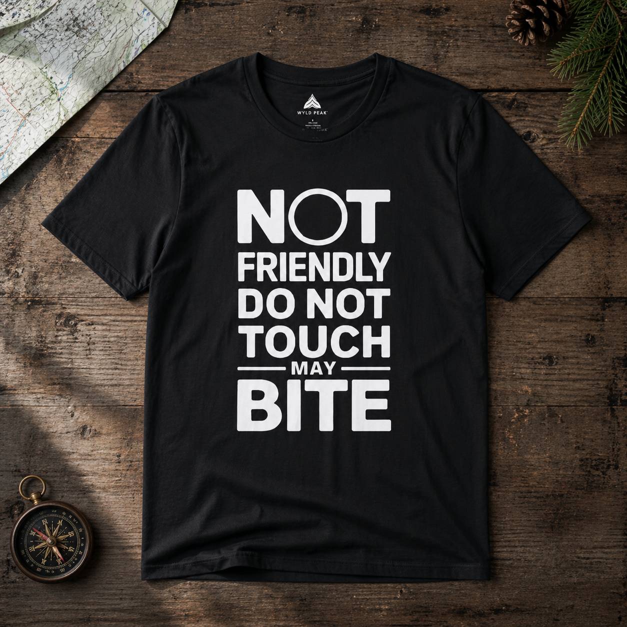 Black t-shirt with white text 'Not Friendly Do Not Touch May Bite' on a wooden surface.