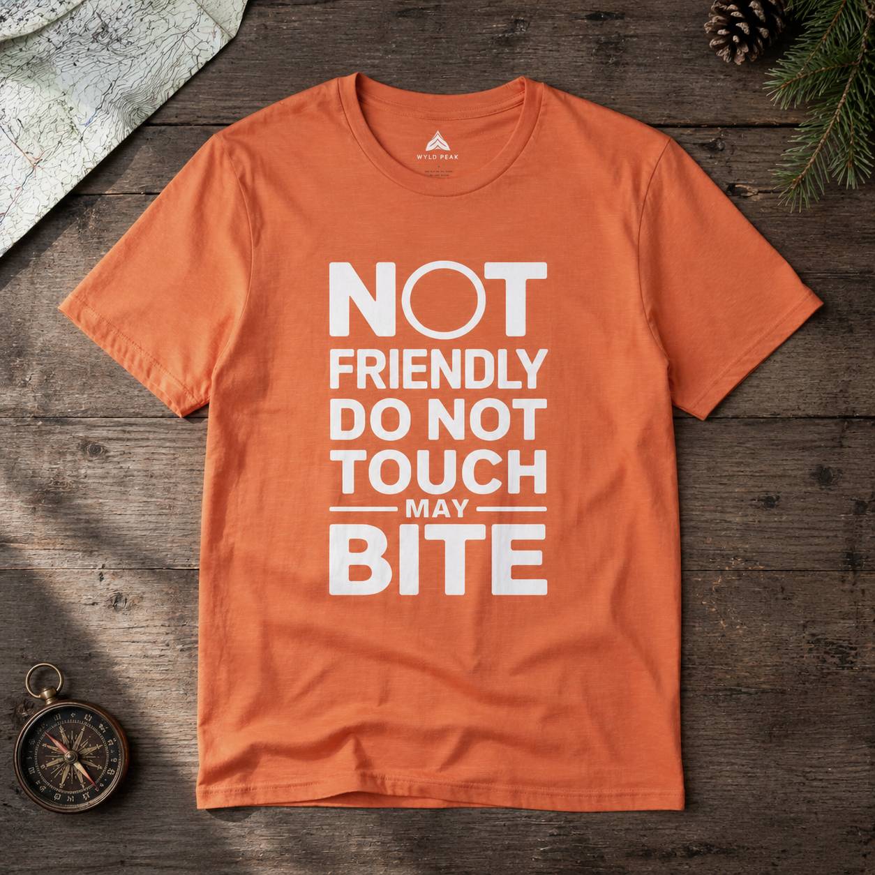 Orange t-shirt with white text on a wooden surface