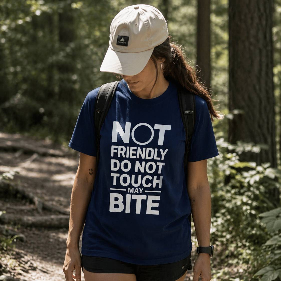 Person wearing a blue t-shirt with text in a forest