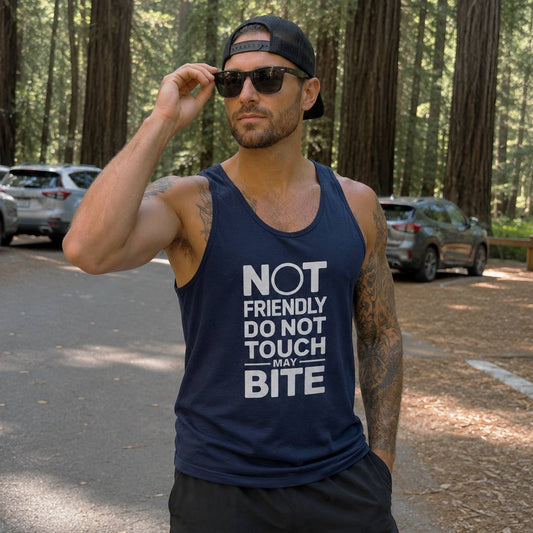 Man wearing a navy tank top with humorous text in a forest setting