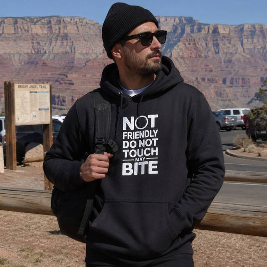 Man wearing a black hoodie with text in front of a desert landscape