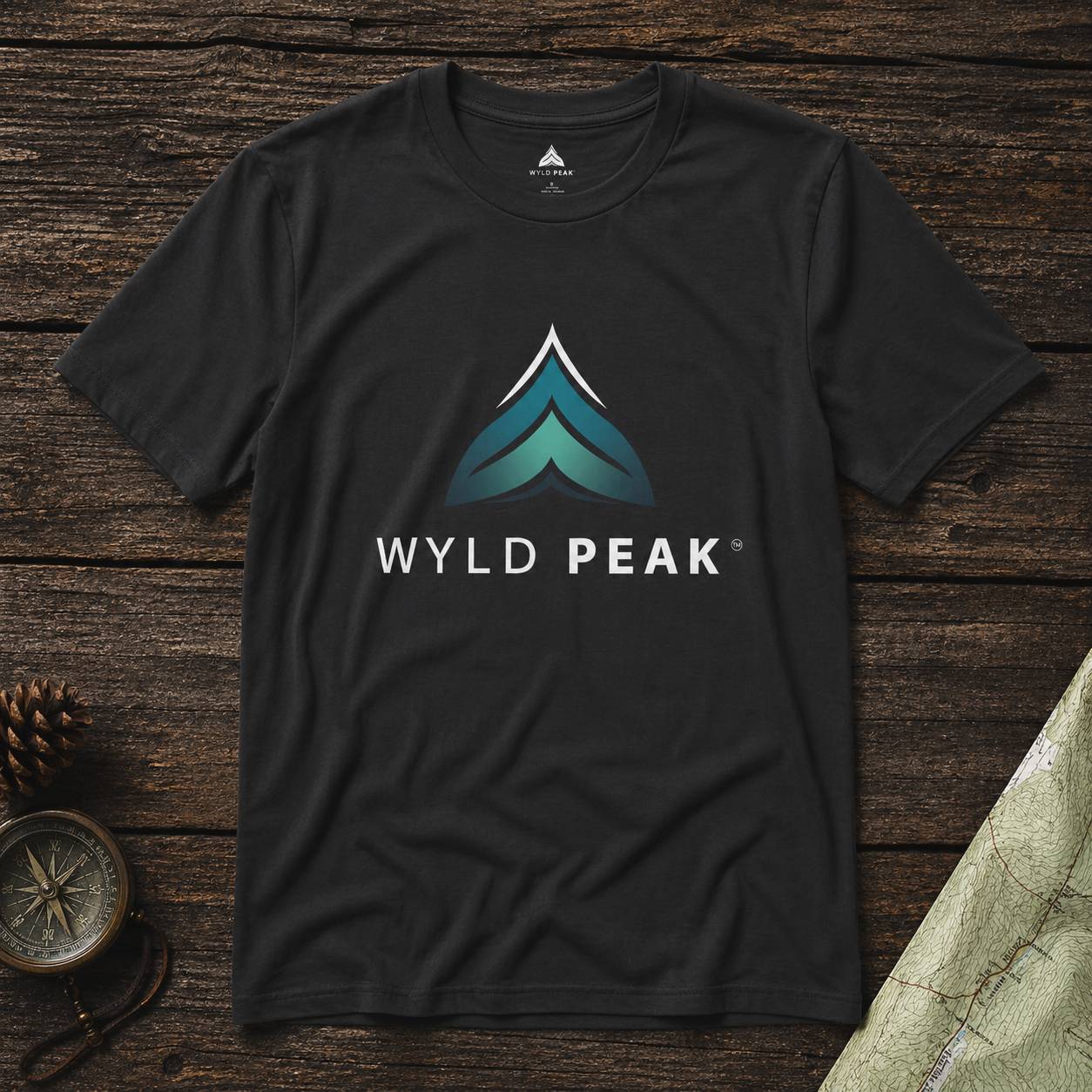 Black t-shirt with Wyld Peak logo on a wooden surface
