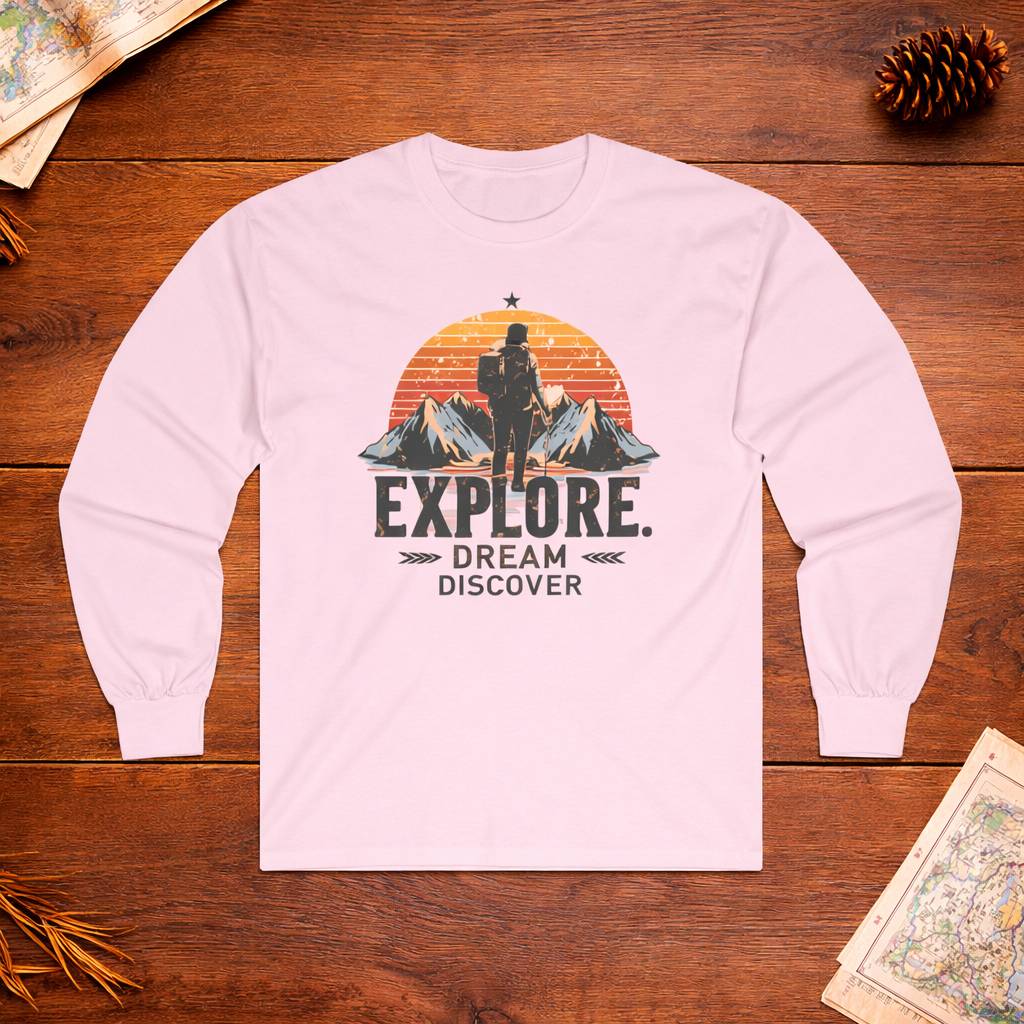 Pink long-sleeve shirt with 'Explore. Dream Discover' design on a wooden surface.