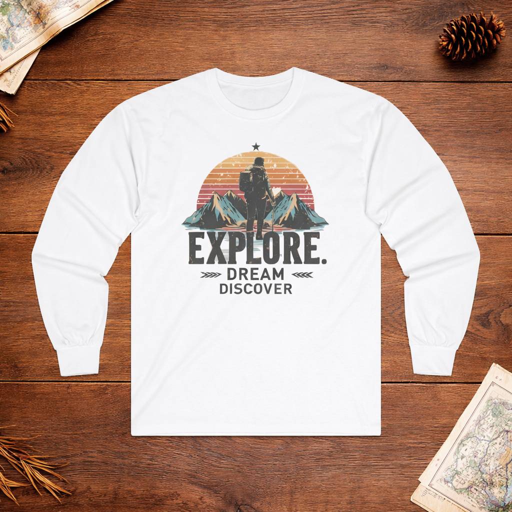 White long-sleeve shirt with 'Explore. Dream Discover' graphic on a wooden surface.