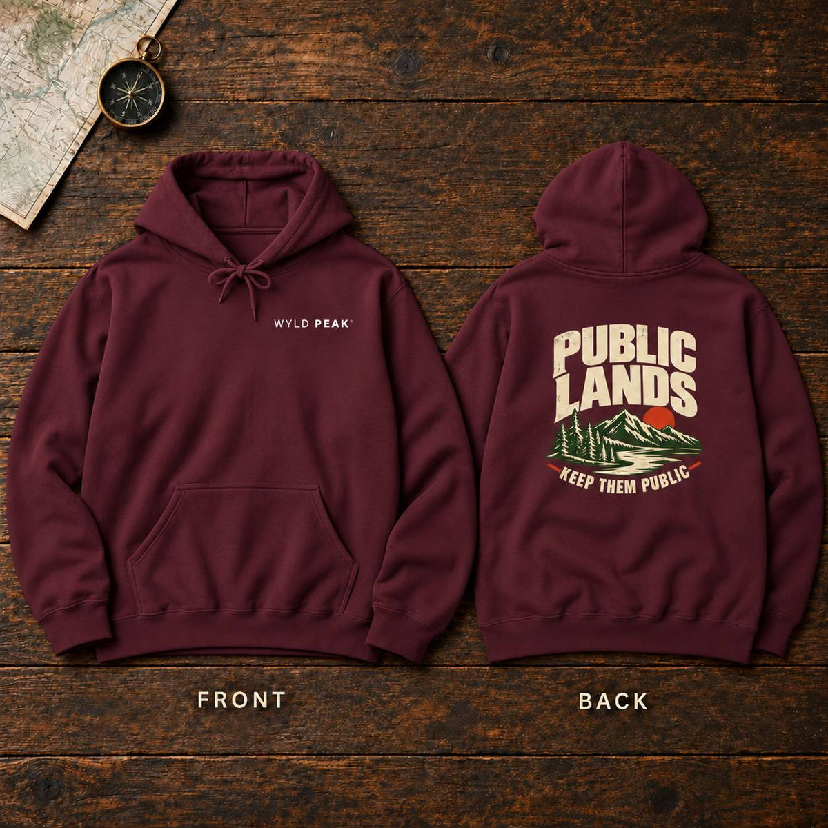 A burgundy pullover hoodie shown from both front and back on a rustic dark wood background. The front has a small white 'WYLD PEAK' logo on the left chest, and the back has a large cream graphic reading 'PUBLIC LANDS' with a mountain illustration and 'KEEP THEM PUBLIC' below.