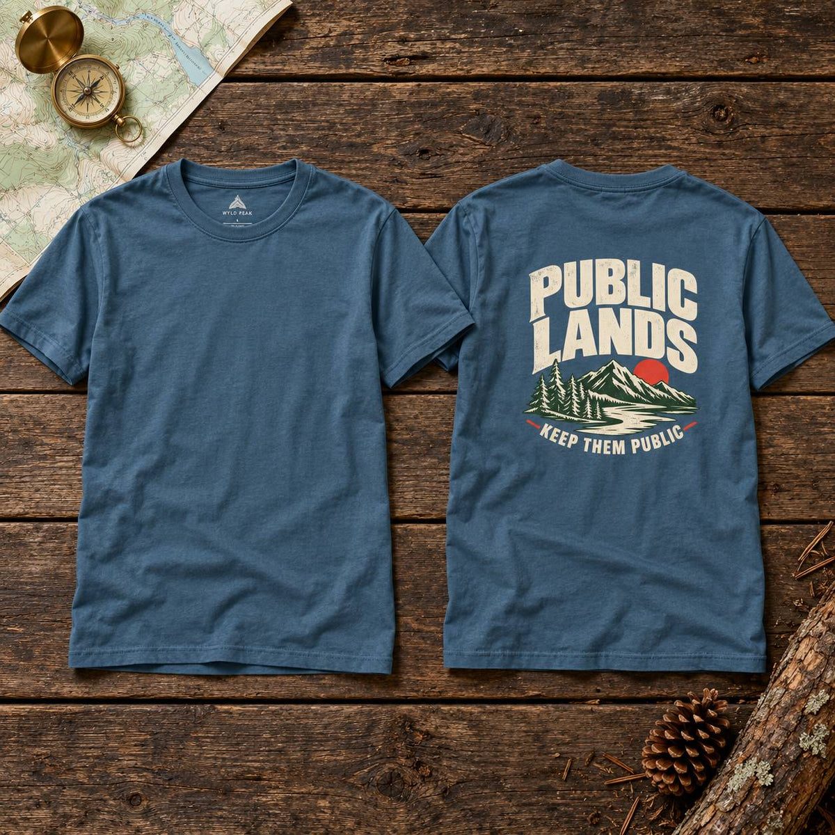Two views of a heathered slate blue t-shirt laid flat on a rustic wooden background. The left shows the plain front, and the right shows the back with a graphic that reads 'PUBLIC LANDS' in cream letters above a mountain and tree illustration with 'KEEP THEM PUBLIC' below.