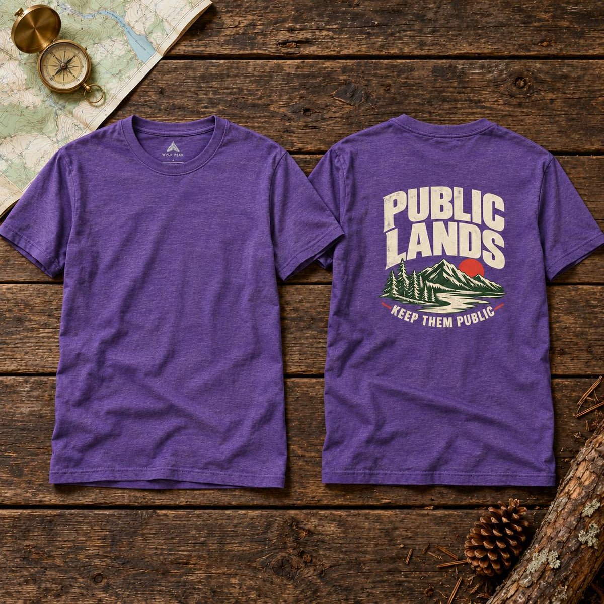 Two purple heather crewneck t-shirts shown flat on a rustic wooden surface, displaying the front and back. The front is solid purple, while the back features a graphic print with the words 'PUBLIC LANDS' in cream, a green mountain, and a small red sun, with 'KEEP THEM PUBLIC' below.