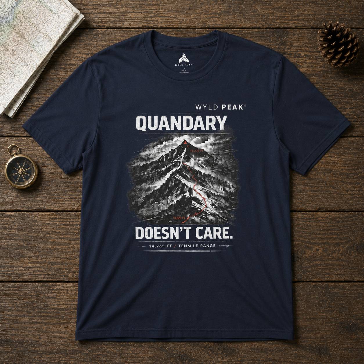 Navy blue t-shirt with mountain graphic and text on a wooden surface