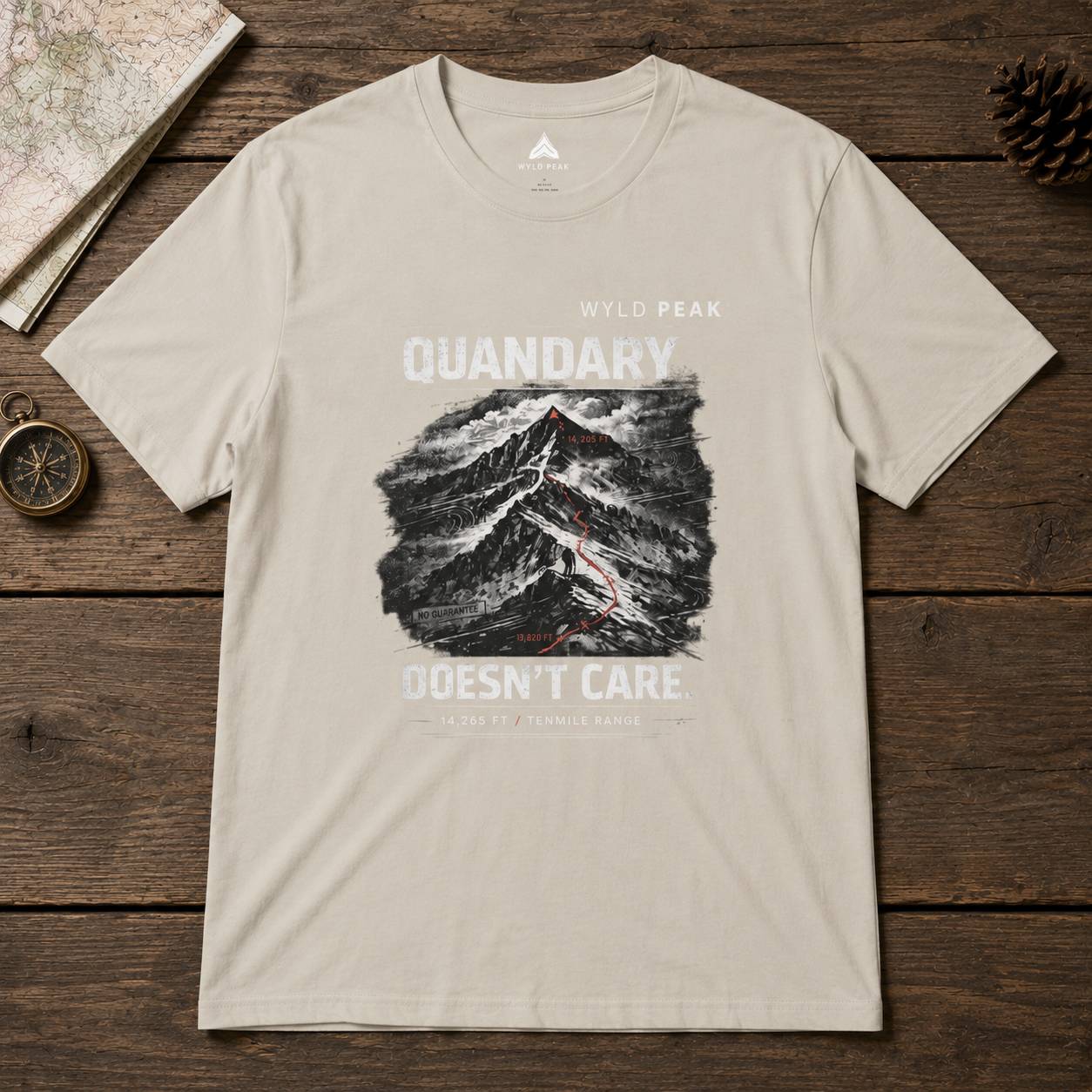 Beige t-shirt with mountain graphic and text on a wooden surface