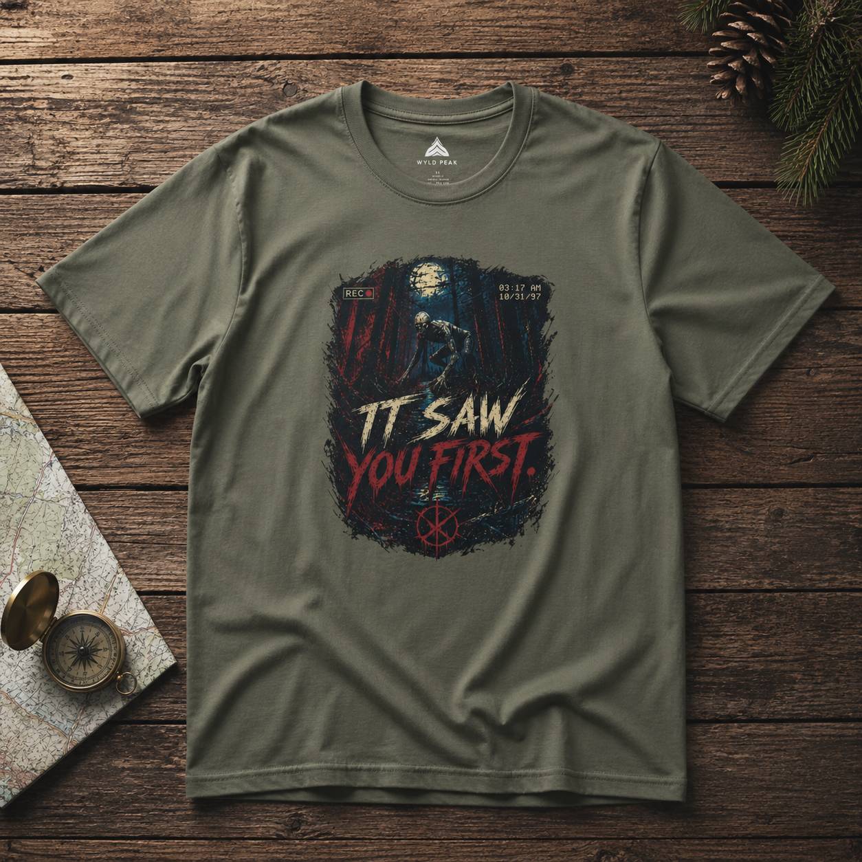 Green t-shirt with rake graphic design and text on a wooden surface