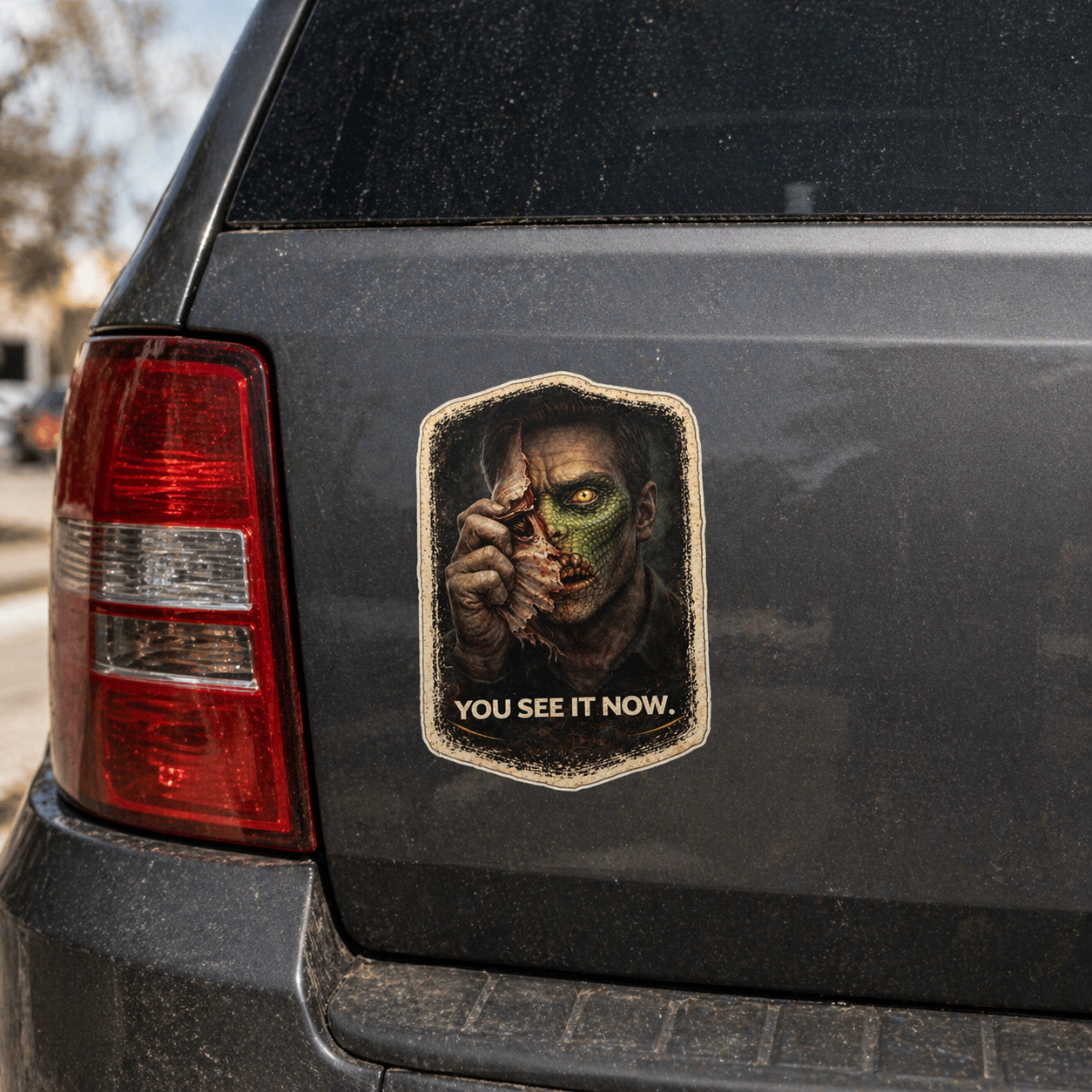 Sticker of a character with a split face on a car's rear window with the text 'You See It Now'.