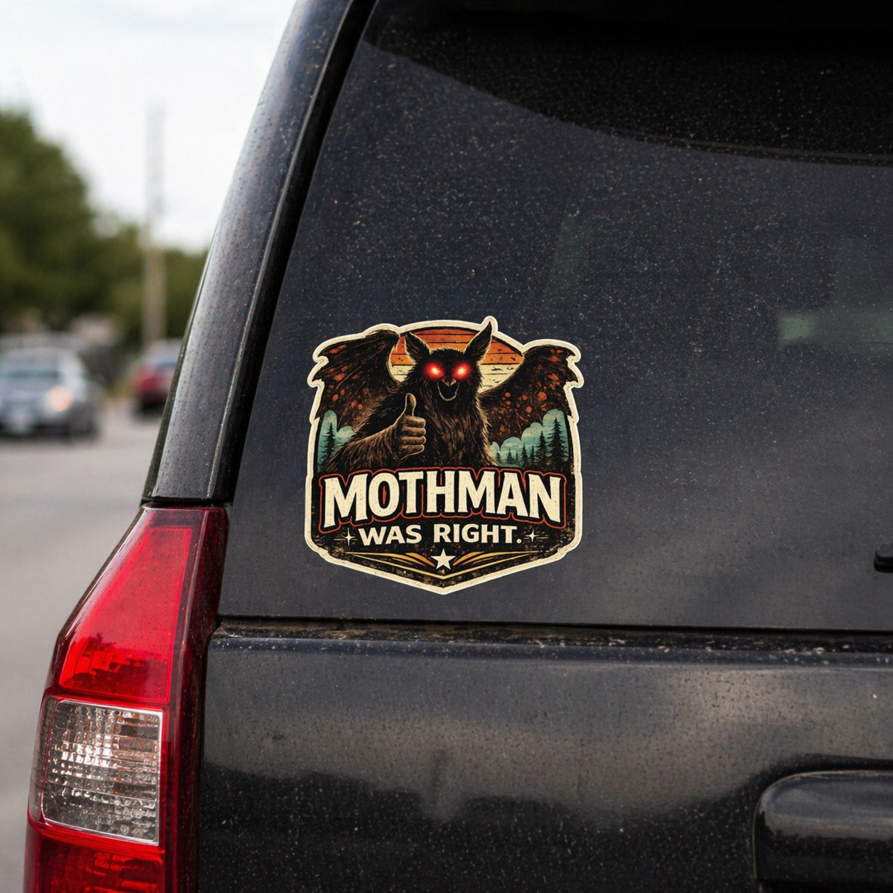 Mothman sticker on a car's rear window with text 'Mothman Was Right'.