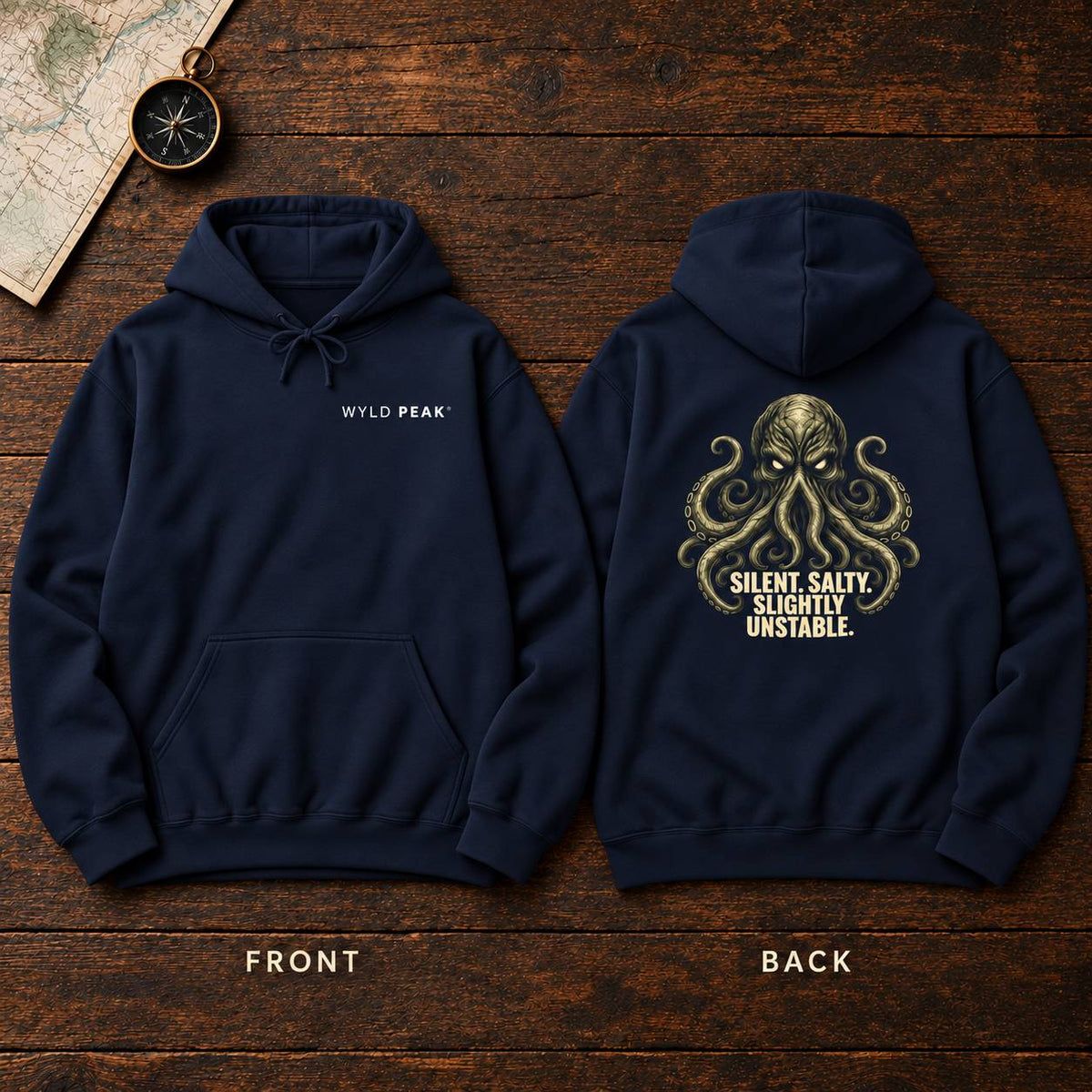 Two navy blue hoodies laid flat on a dark wood background, showing the front and back designs. The front hoodie has small white 'WYLD PEAK' text on the chest.