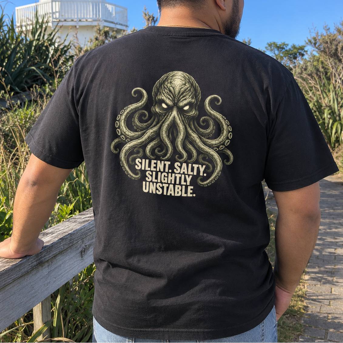 man viewed from behind wearing a black t-shirt with a large graphic of a tentacle creature kraken and the text 'SILENT, SALTY. SLIGHTLY UNSTABLE.