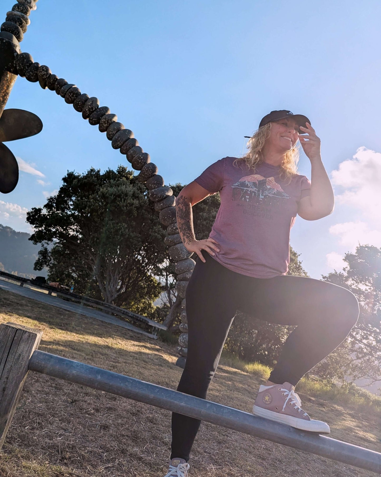 Sim Bastick posing at the Rainbow Warrior Memorial in Wyld Peak maroon Explorers tee