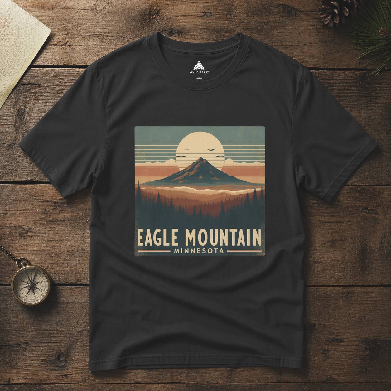 Black t-shirt with 'Eagle Mountain, Minnesota' design on a wooden surface