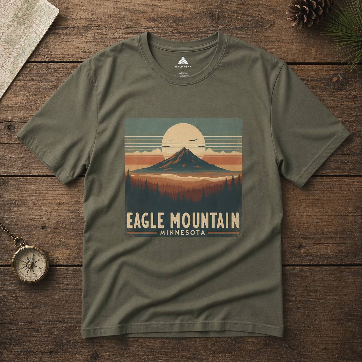 Green t-shirt with 'Eagle Mountain, Minnesota' design on a wooden surface