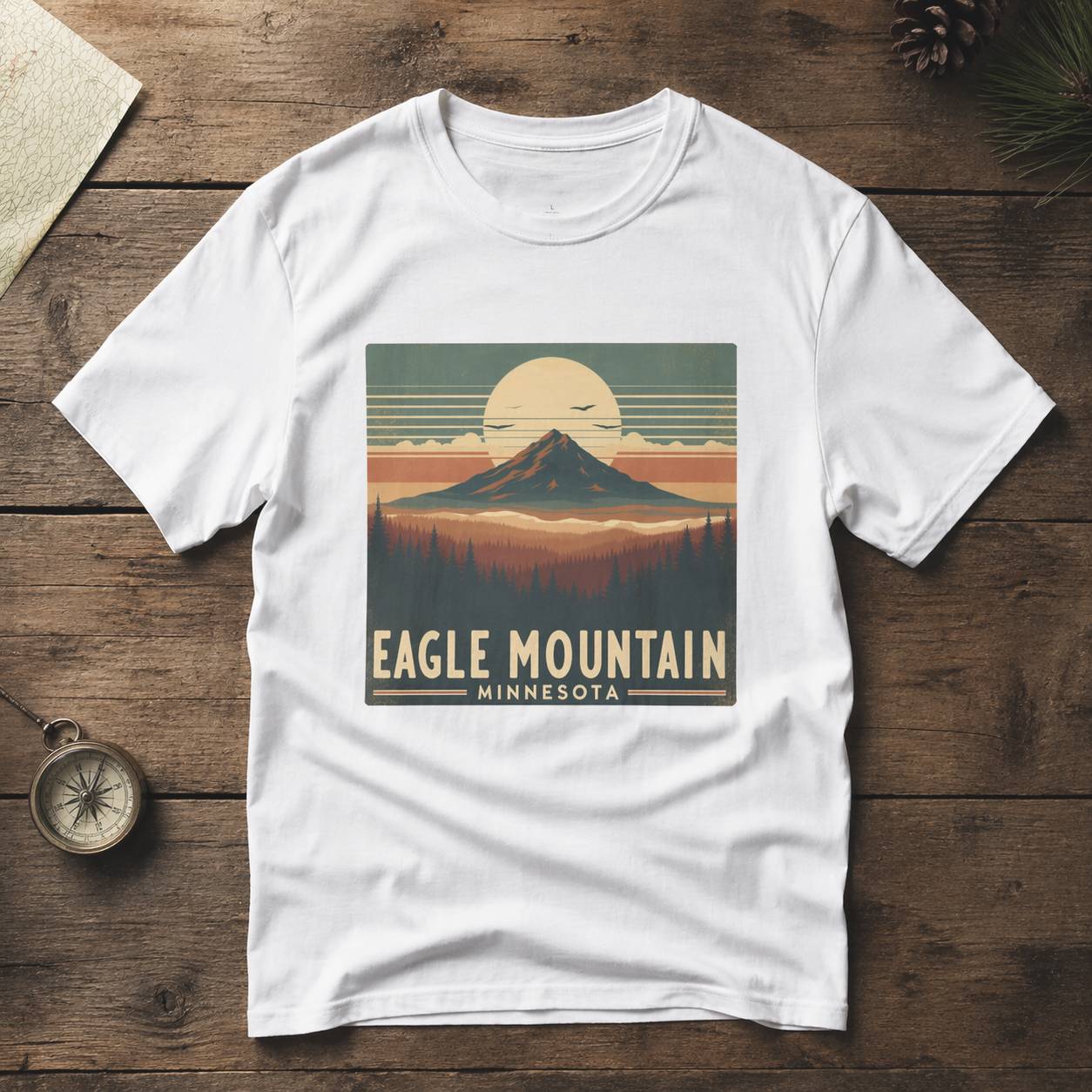 White t-shirt with 'Eagle Mountain, Minnesota' graphic on a wooden surface