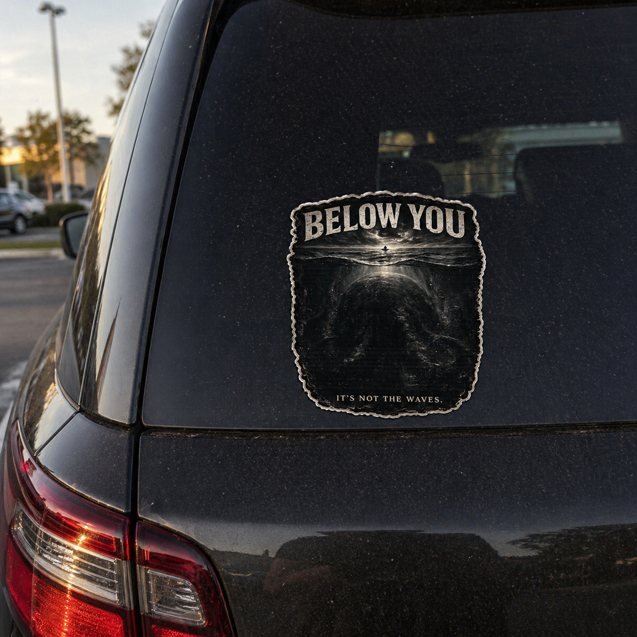 Sticker on a car window with text 'Below You' and an ocean design.
