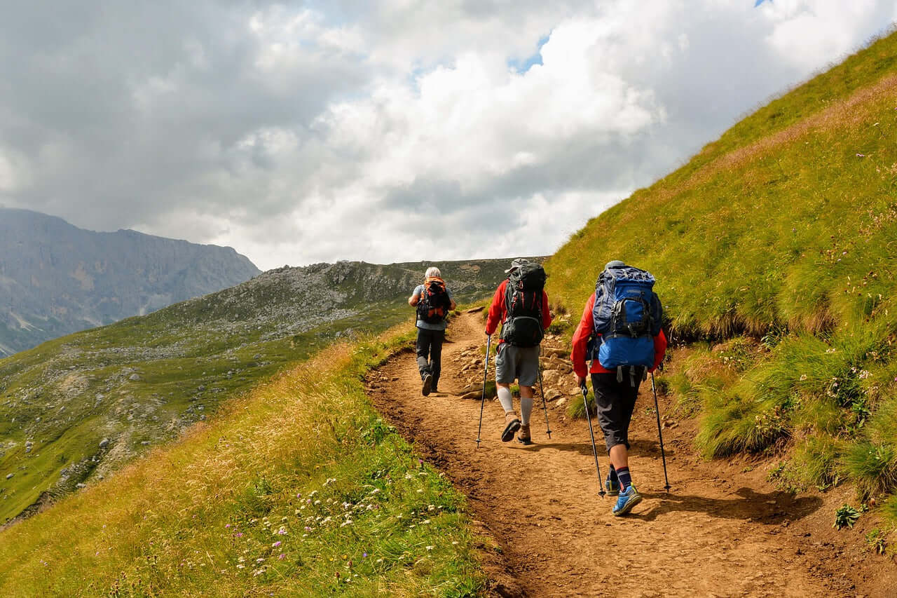 Three hikers in gear trekking along a scenic Yorkshire trail.