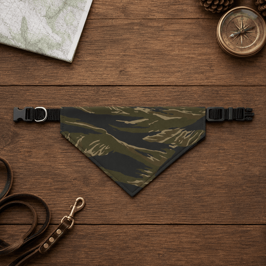 Camouflage dog bandana on a wooden surface with a leash and compass.