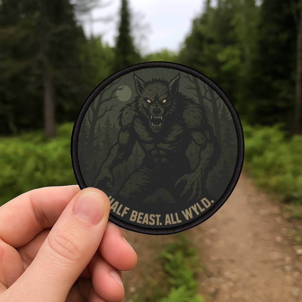 Wyld Peak Dogman patch being held on a misty backroad hiking trail