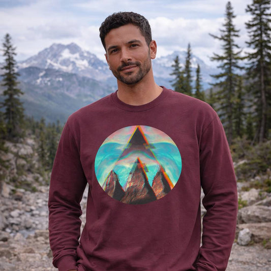 Man wearing a maroon long-sleeve shirt with a mountain graphic in a natural setting