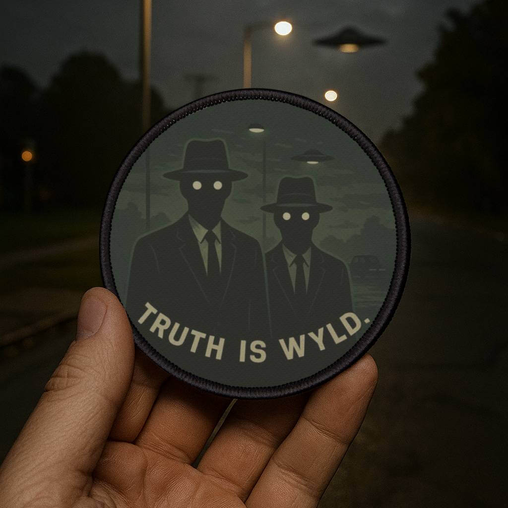 Wyld Peak Men in Black cryptid patch being held in a dimly lit carpark at night