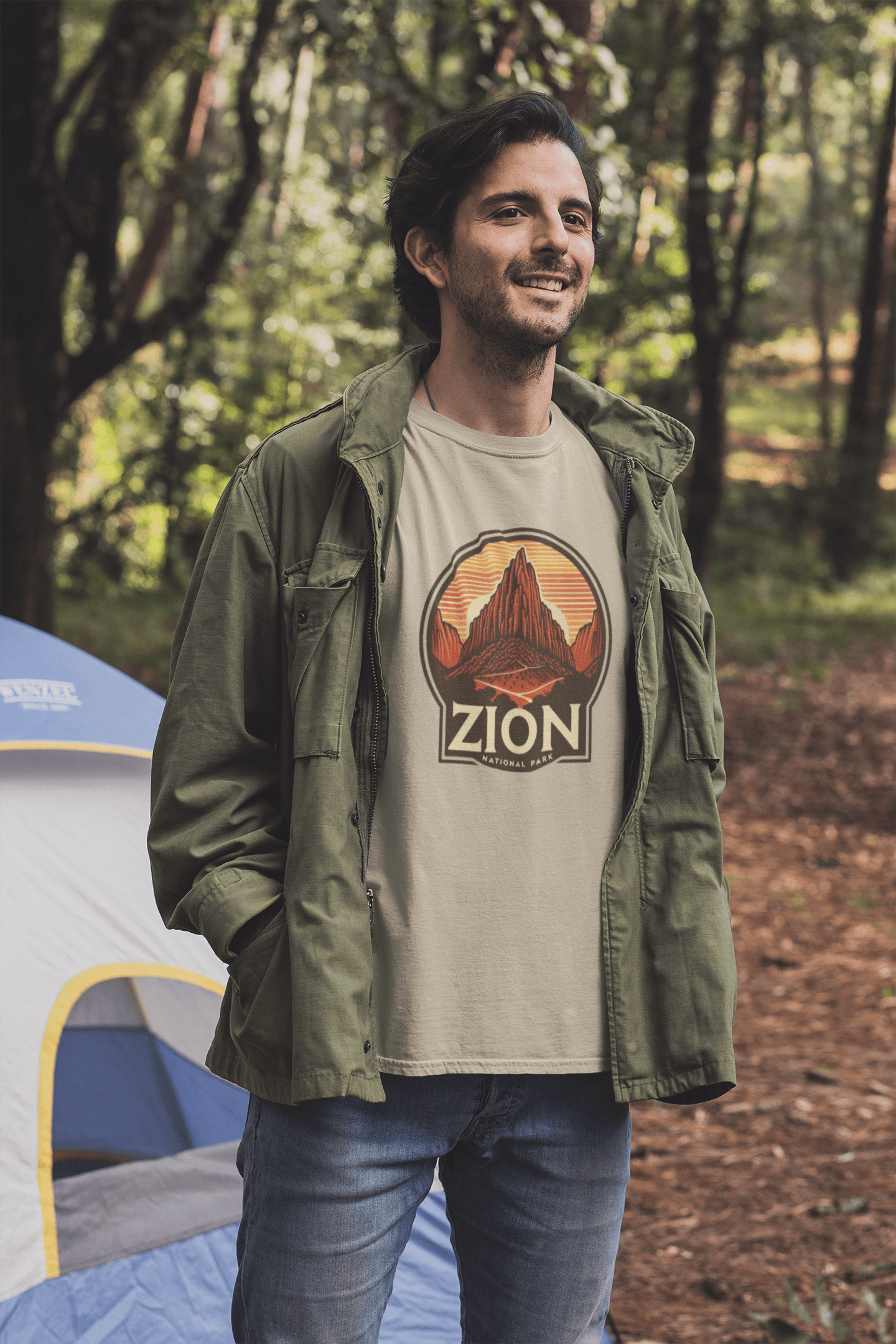 Desert tan Angels Landing Zion National Park tee from Wyld Peak worn by man at campsite.