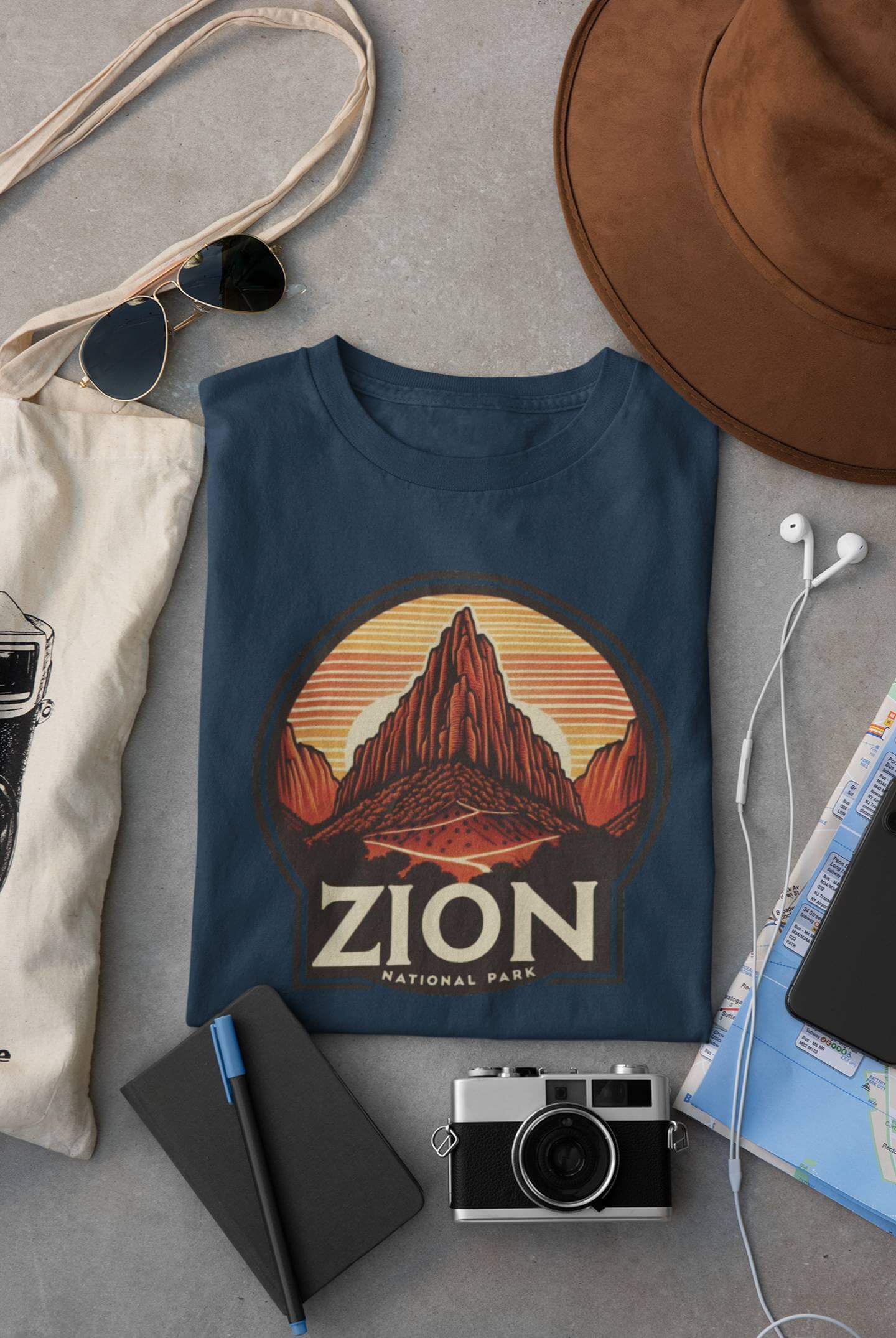 Indigo blue Angels Landing Zion National Park tee from Wyld Peak flat lay on desk.