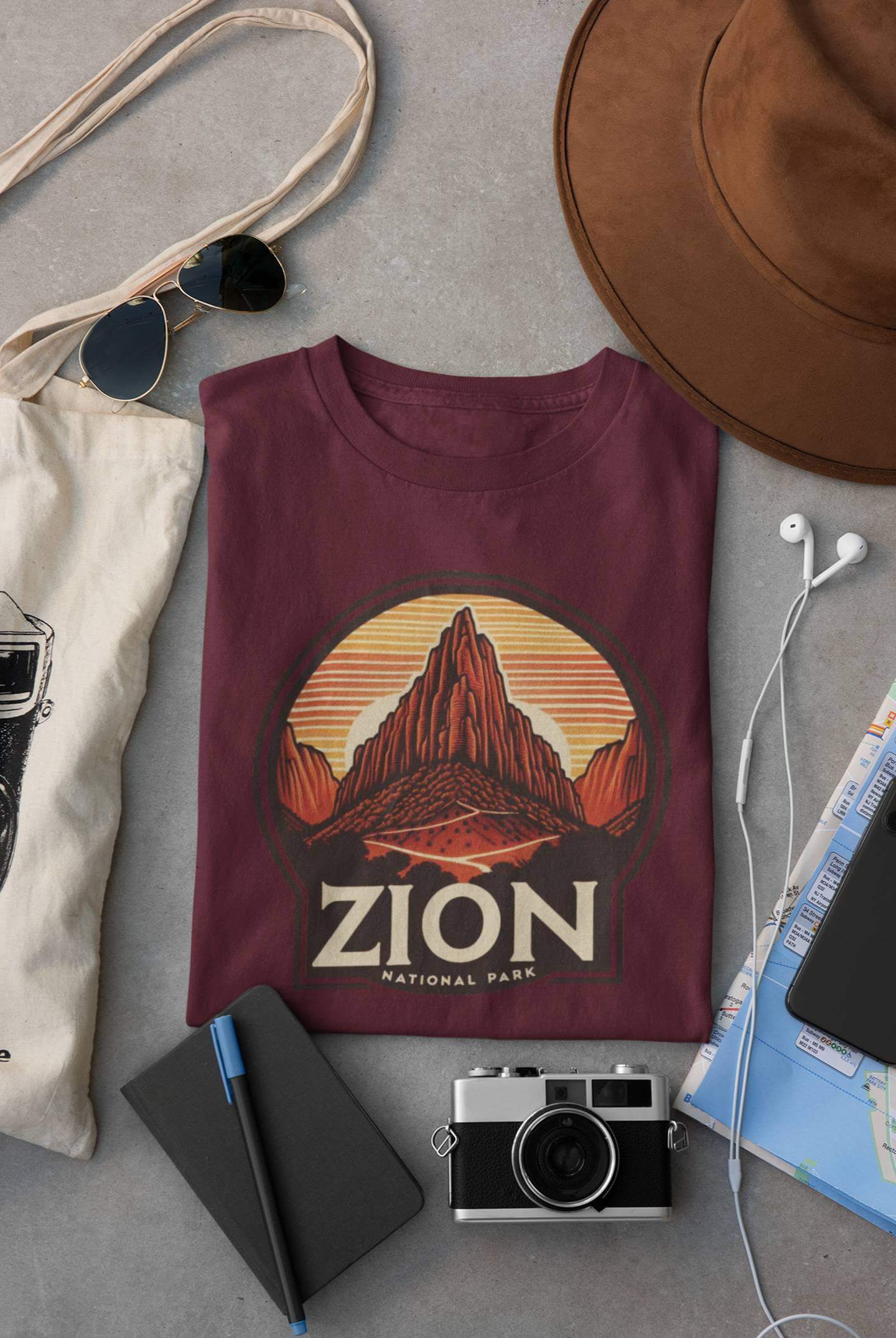 Maroon Angels Landing Zion National Park tee from Wyld Peak flat lay on desk.