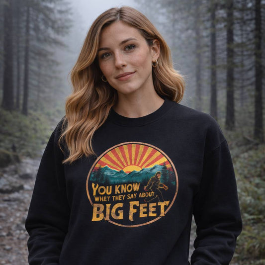 Woman wearing a black sweatshirt with a graphic design in a forest setting