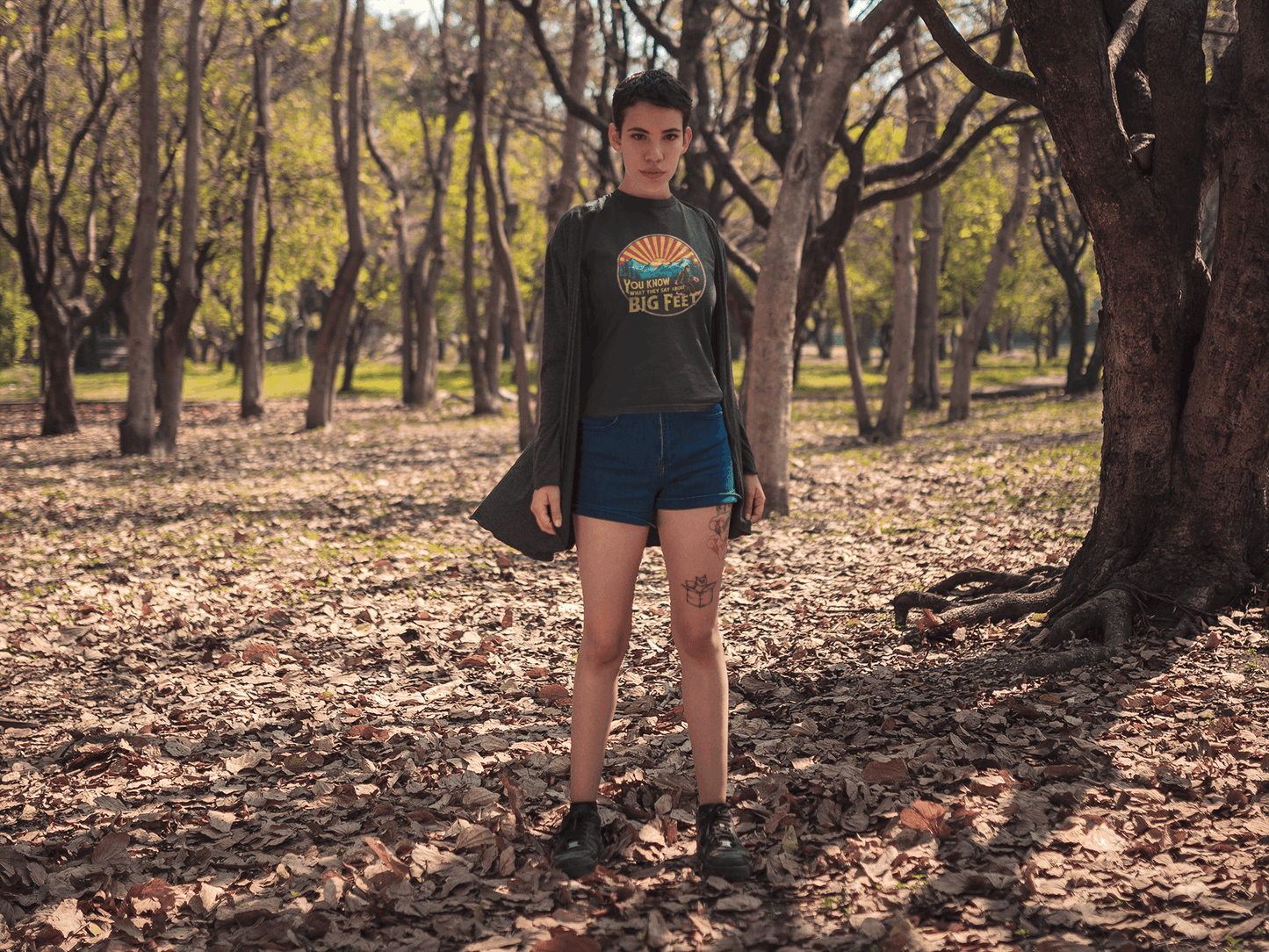 Hiker on a forest trail wearing a black Wyld Peak Bigfoot women's organic t-shirt
