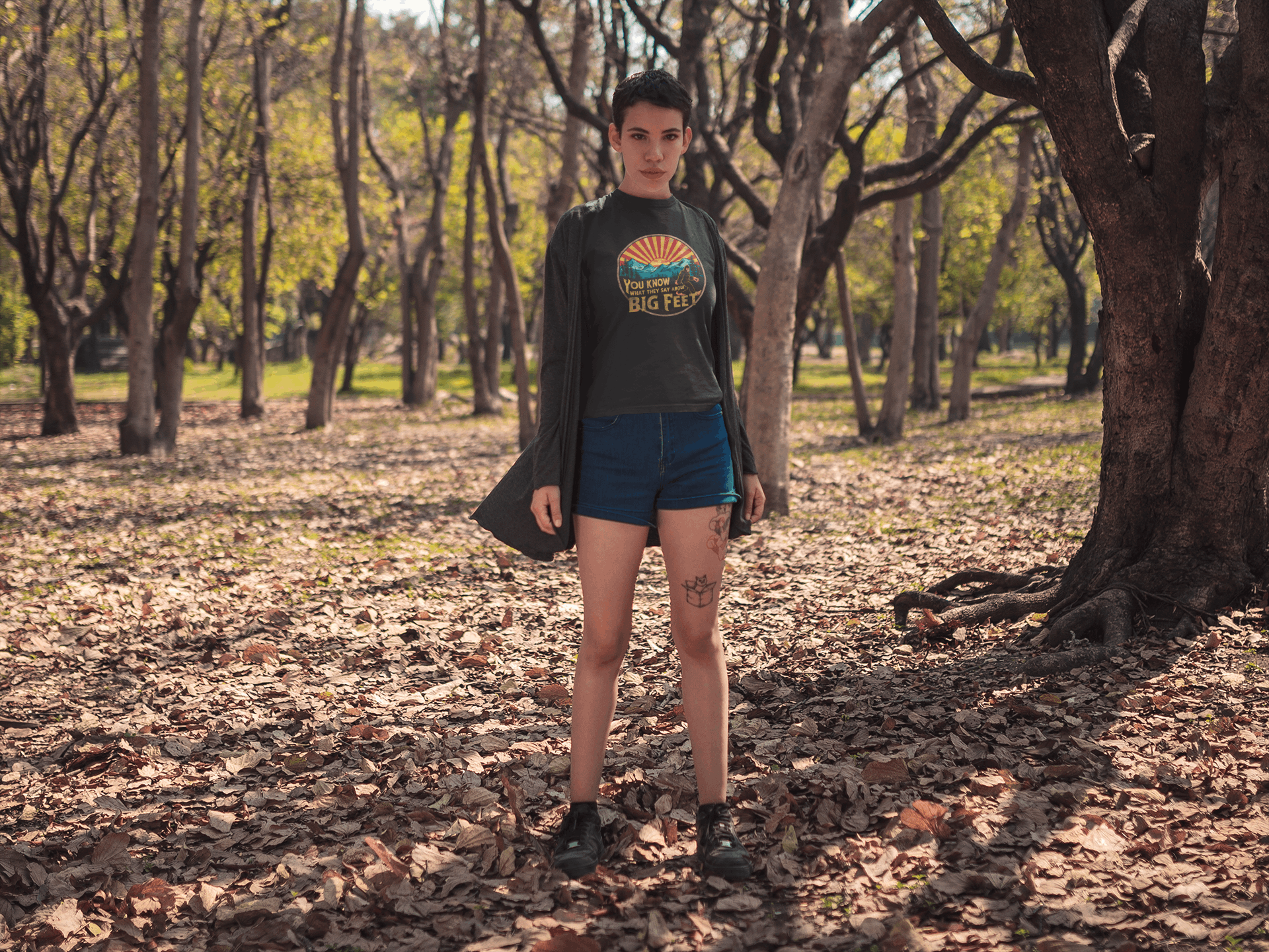 Hiker on a forest trail wearing a black Wyld Peak Bigfoot women's organic t-shirt