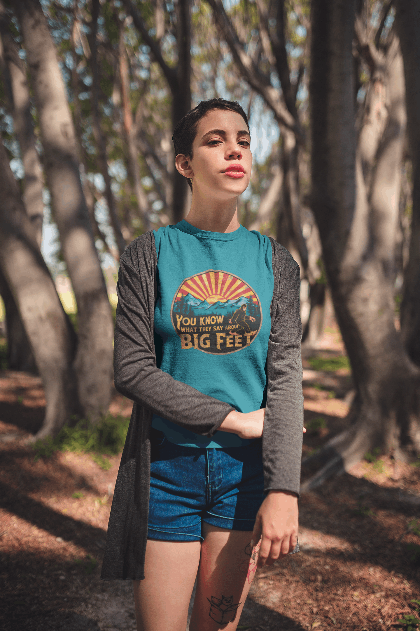 Hiker on a trail wearing a blue Wyld Peak Bigfoot women's organic t-shirt