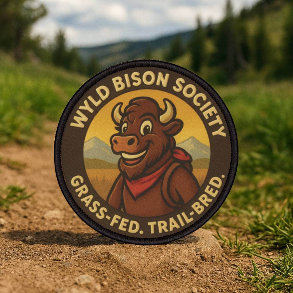 Bison Society patch held in a forest setting, heritage inspired outdoor design for rugged gear