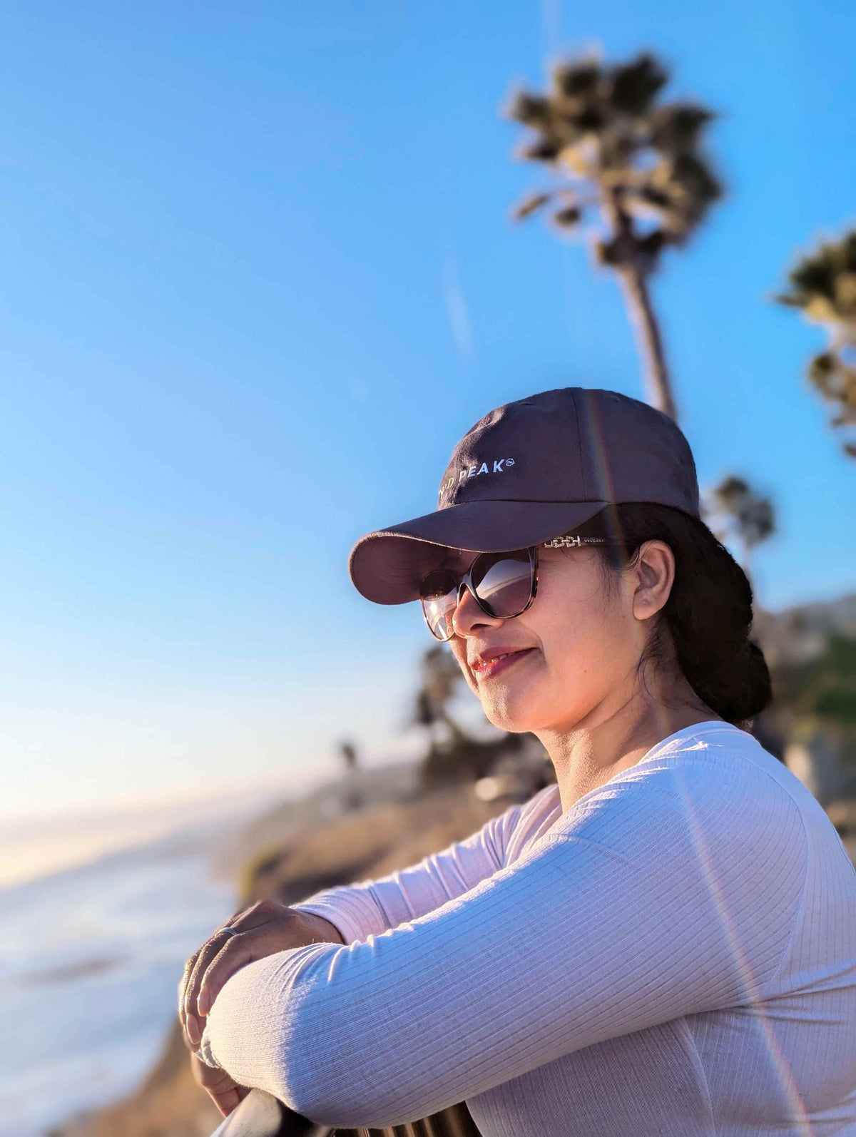 Roxanna wearing a Wyld Peak signature cap in San Pedro, Los Angeles, during a coastal sunset.