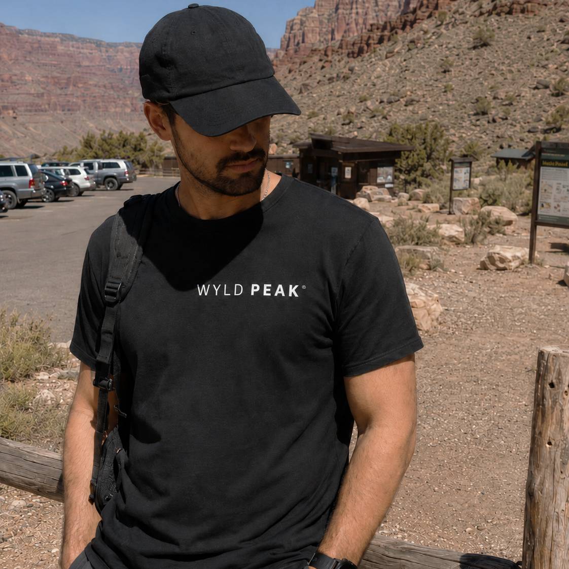 Man wearing a black 'WYLD PEAK' t-shirt in a desert setting