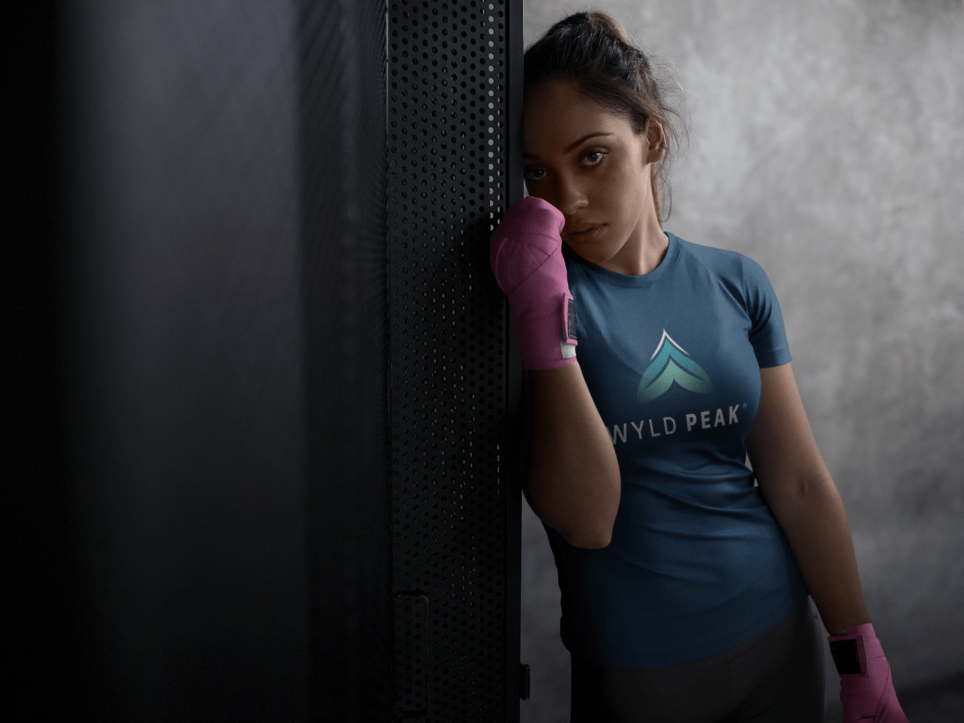 Woman at boxing gym wearing black Wyld Peak branded tee.