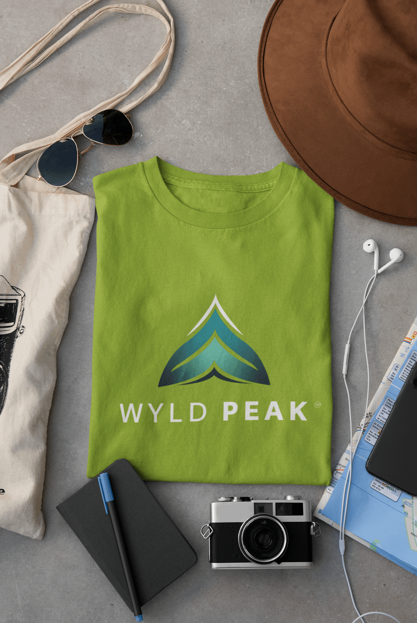 Lime green Wyld Peak women’s branded tee laid flat on desk.