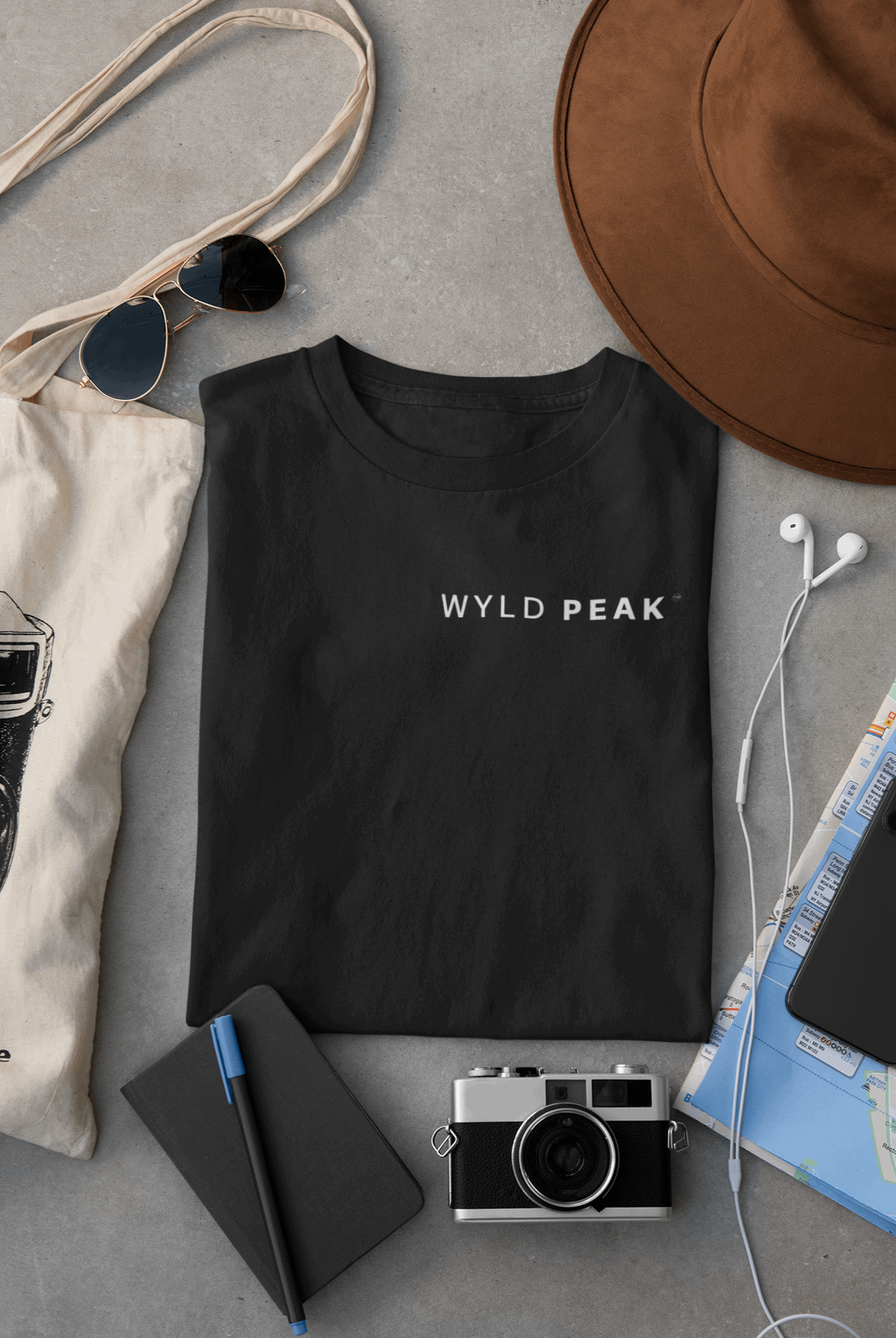 Wyld Peak women’s signature tee in black laid flat on desk.