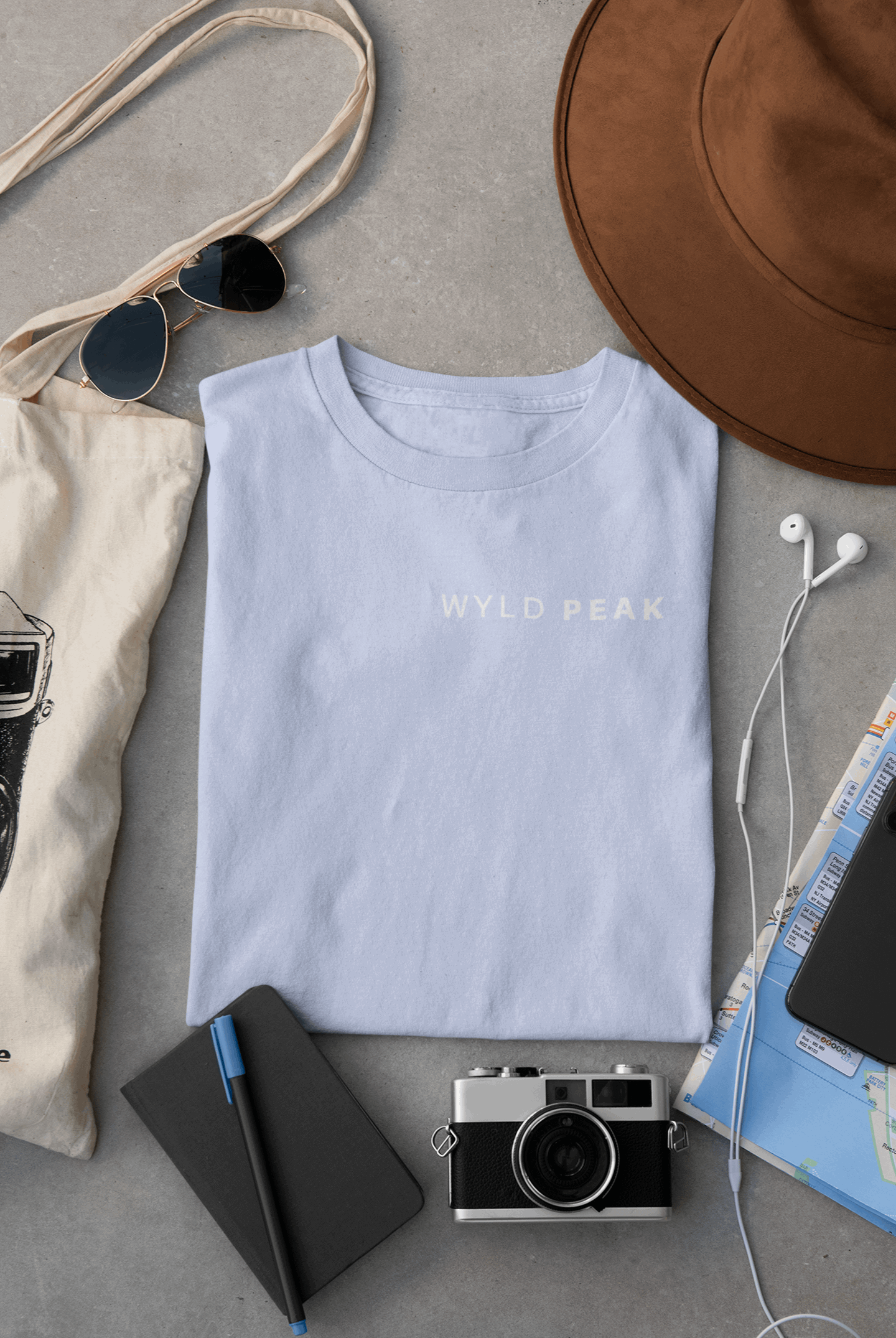 Wyld Peak women’s signature tee in light blue laid flat on desk.