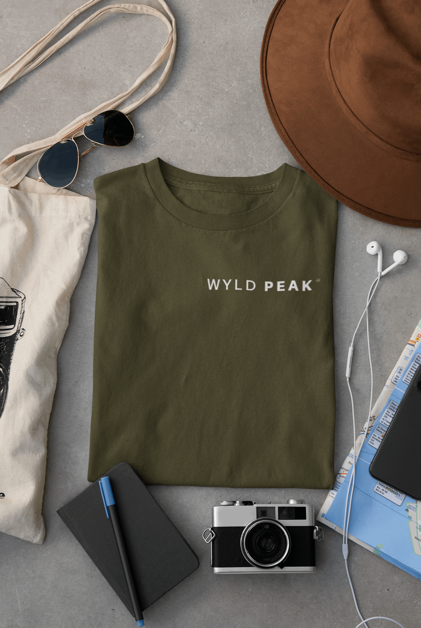 Wyld Peak women’s signature tee in military green laid flat on desk.