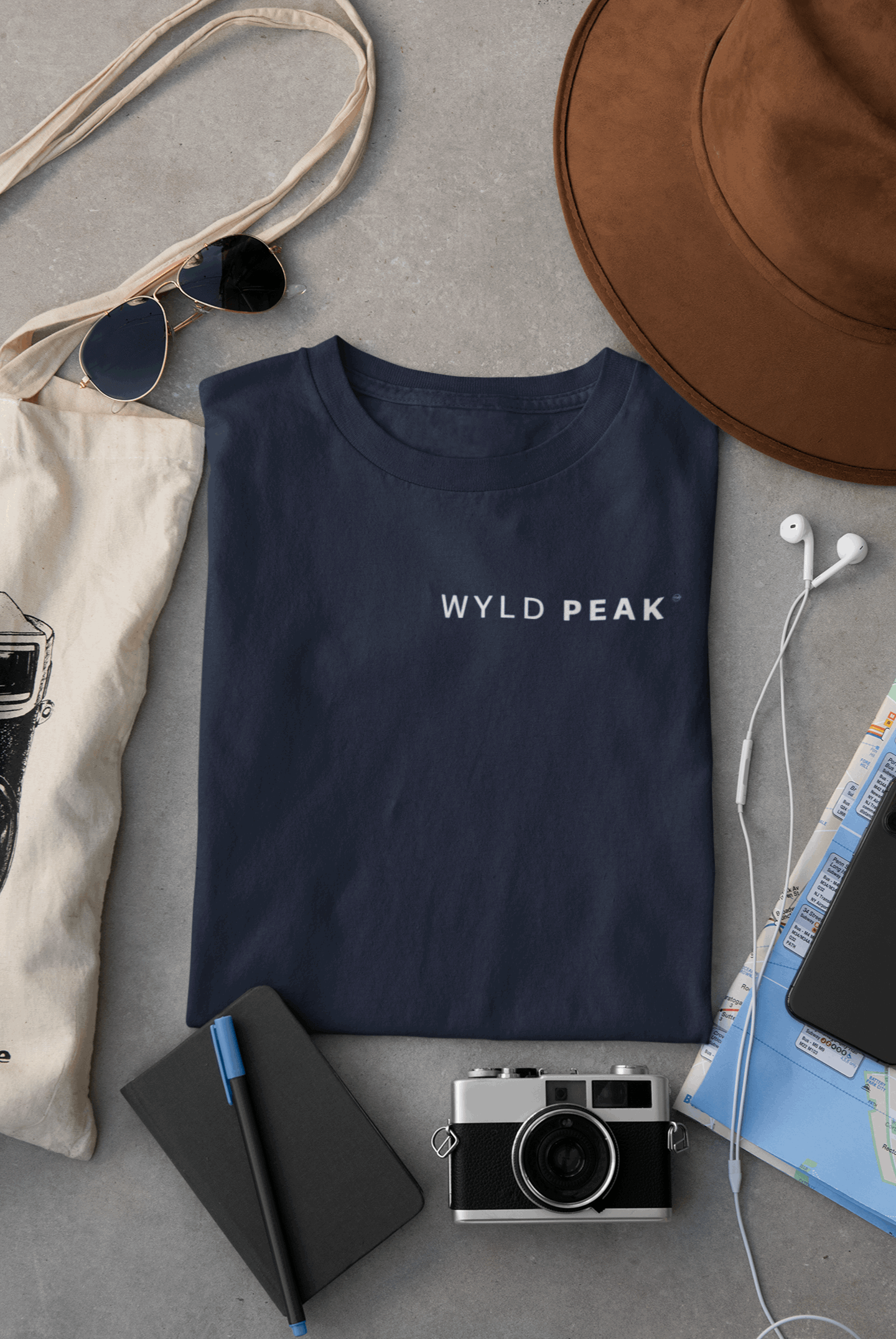 Wyld Peak women’s signature tee in navy laid flat on desk.