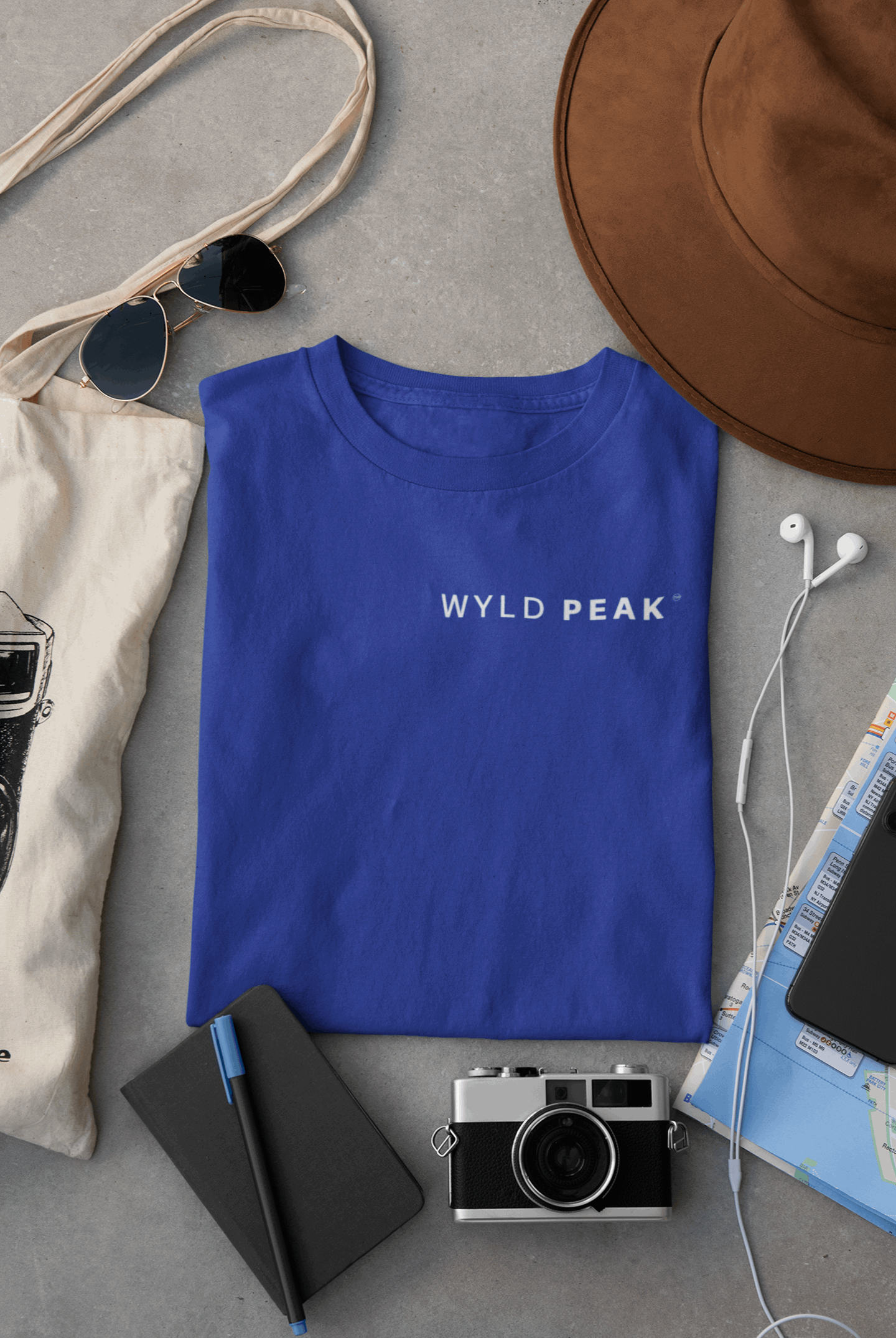 Wyld Peak women’s signature tee in royal blue laid flat on desk.