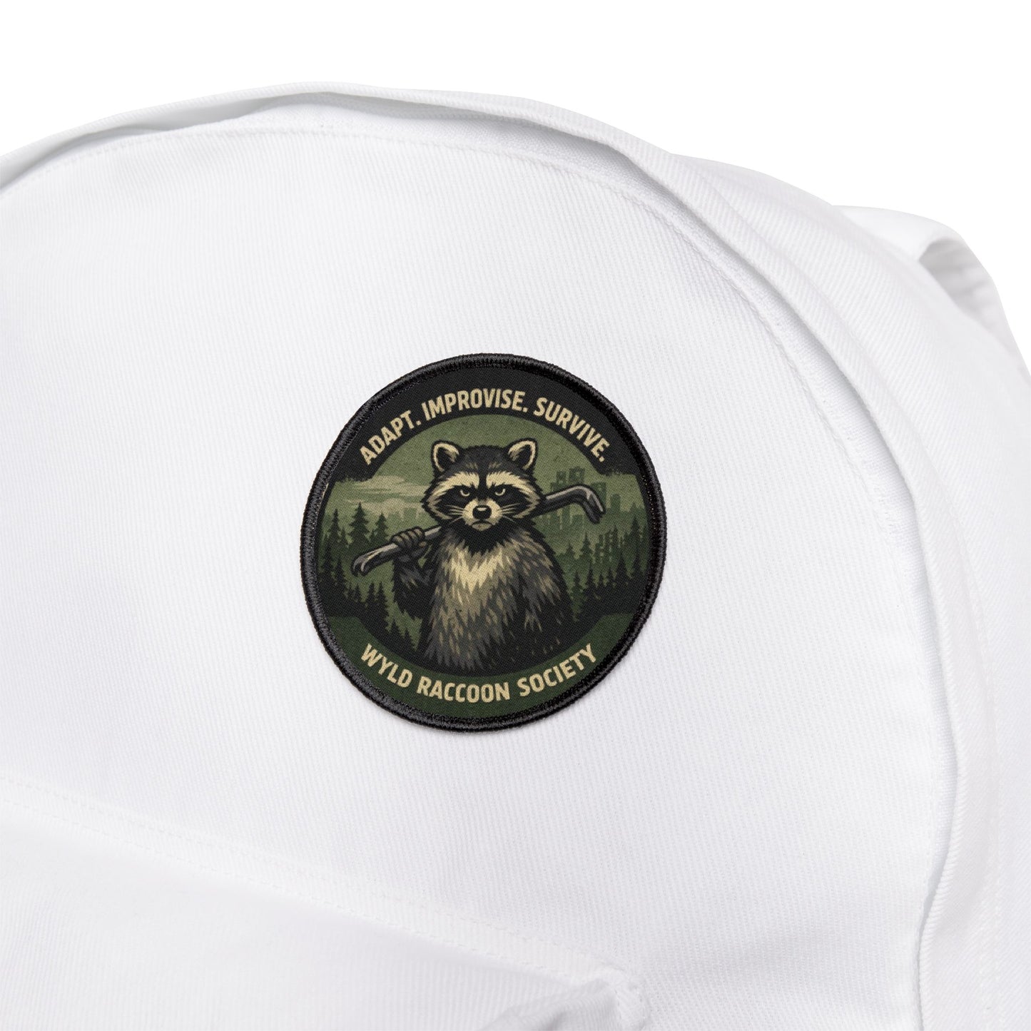 Wyld Raccoon Society patch attached to a white backpack, durable patch built for travel and outdoor use