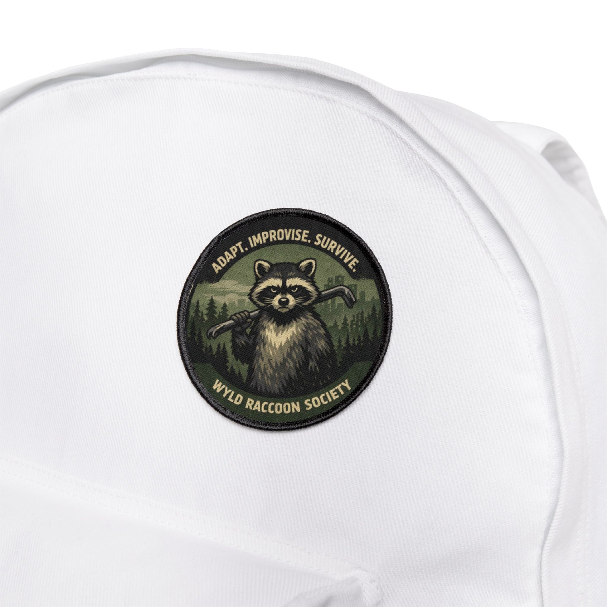Wyld Raccoon Society patch attached to a white backpack, durable patch built for travel and outdoor use
