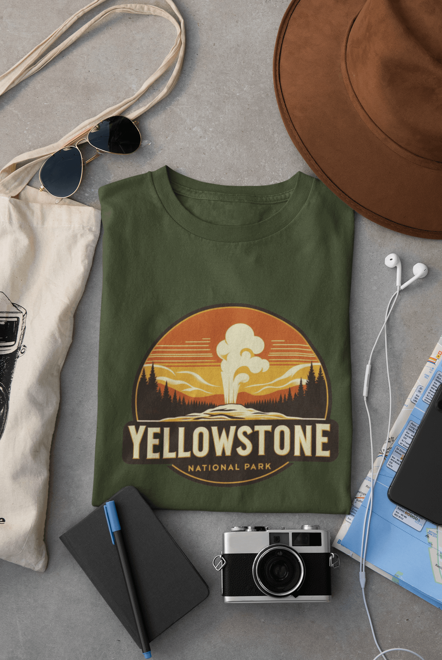 Military green Yellowstone National Park tee from Wyld Peak flat lay on desk.