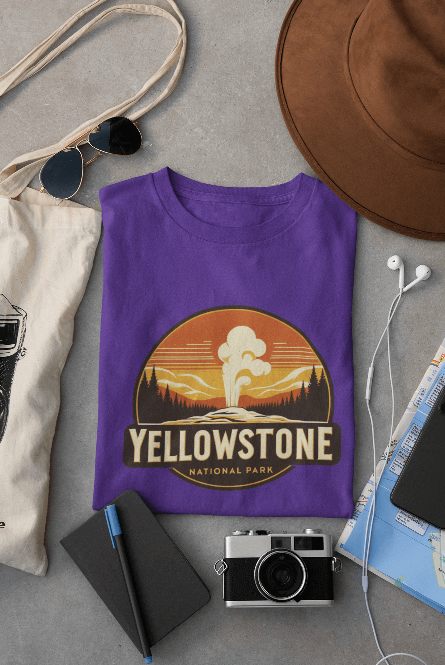 Purple Yellowstone National Park tee from Wyld Peak flat lay on desk.