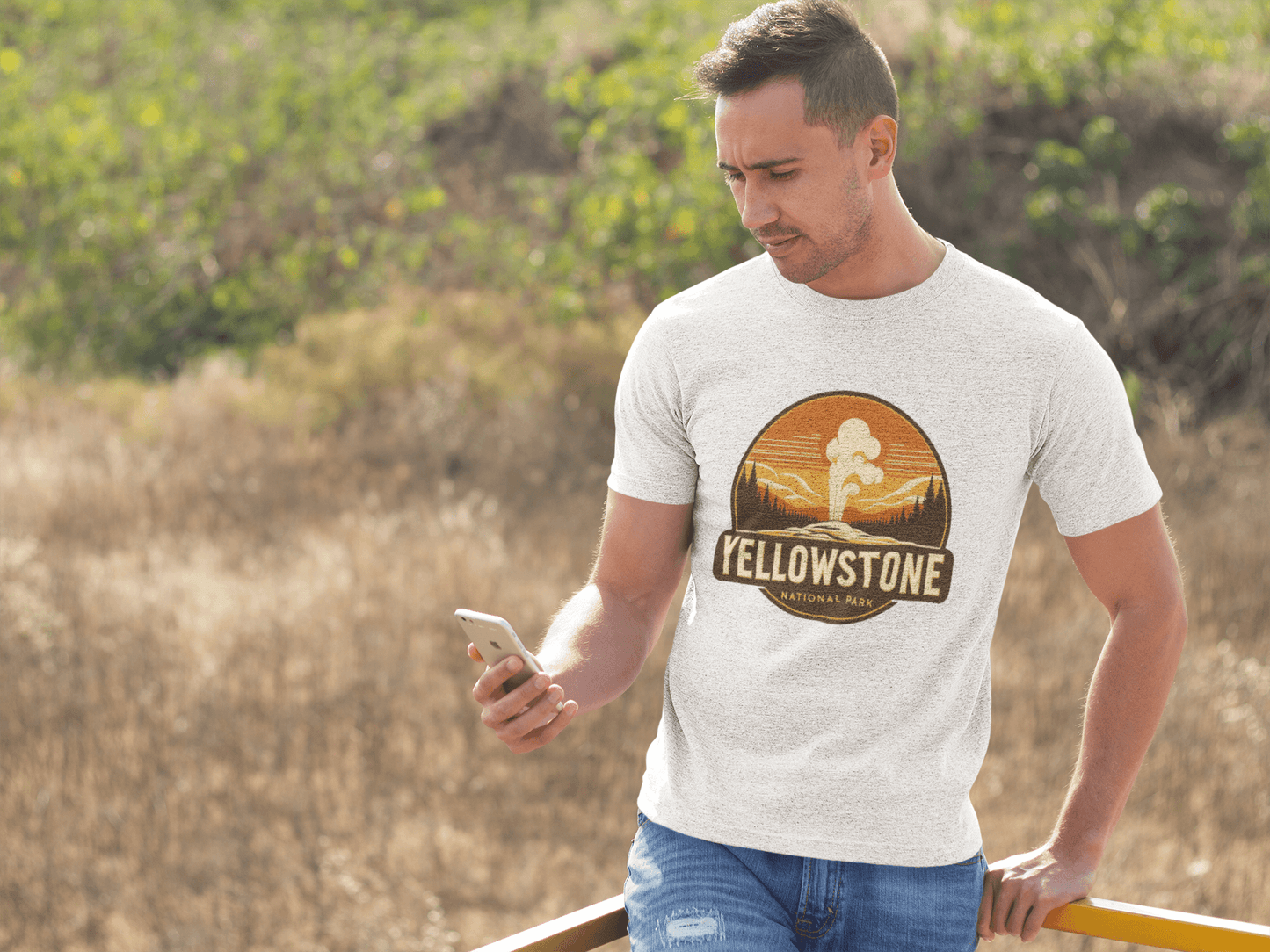 White Yellowstone National Park tee from Wyld Peak worn by man at scenic Yellowstone lookout.
